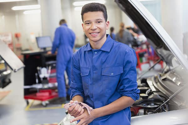 A CTE student standing in n auto shop