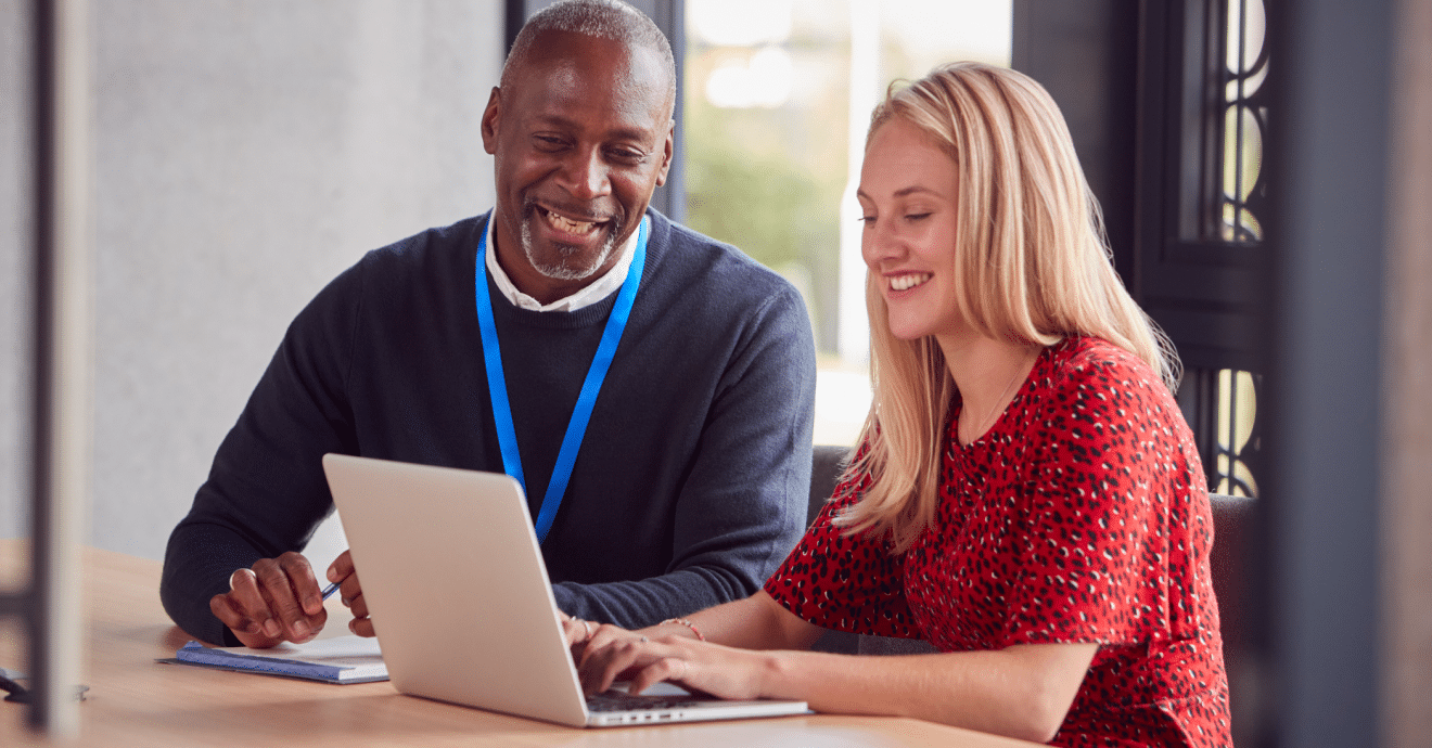 Two coworkers working with a laptop together